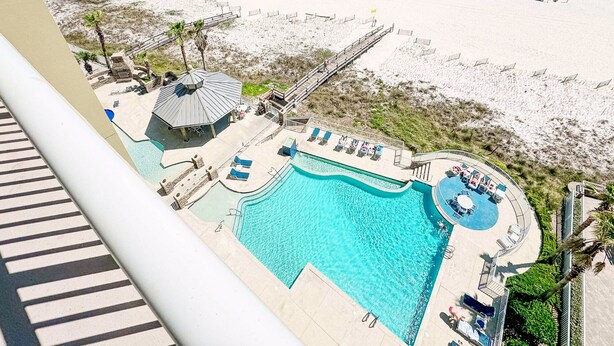 Strandresort med swimmingpool, strandparasoller og en redningsplatform.