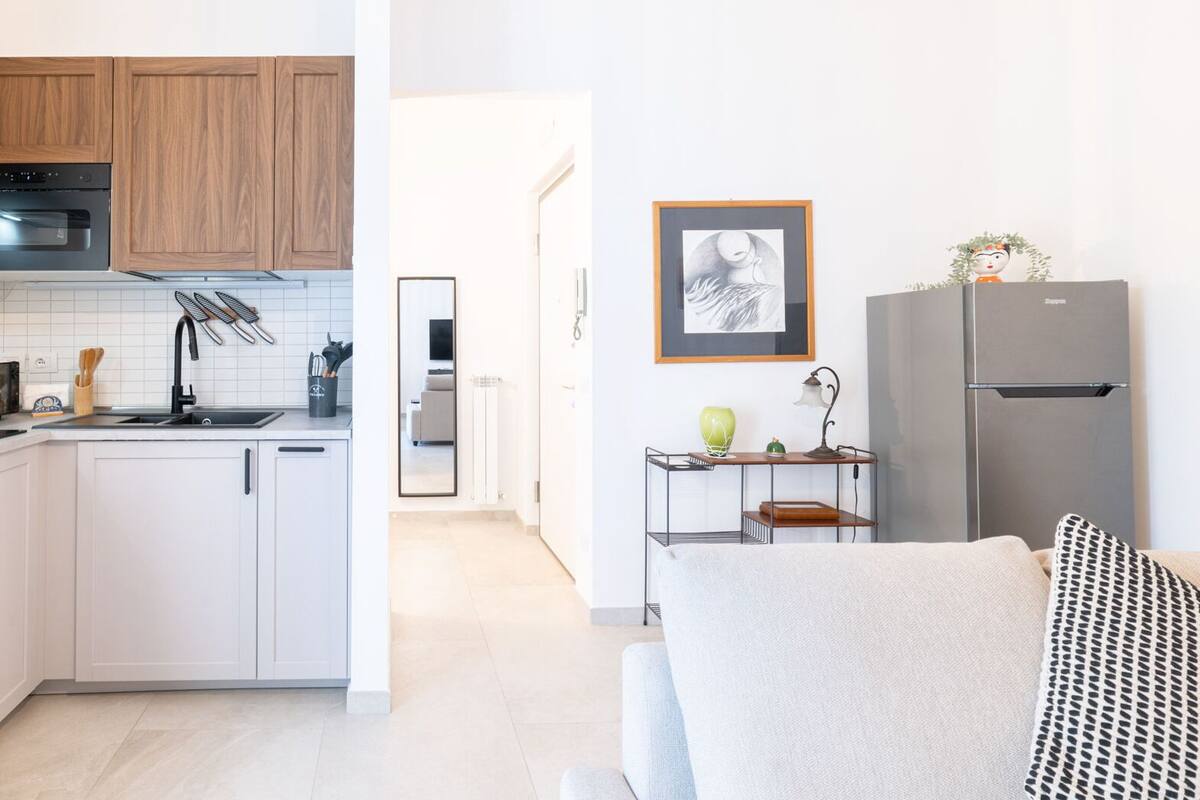 Eine moderne Küche mit Holzausstattung, einem eingebauten Backofen und einem Edelstahl-Kühlschrank.