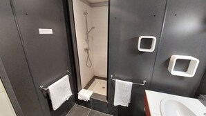 A modern bathroom with a walk-in shower, a sink, and a toilet. - Le relais des garrigues (Grisolles)