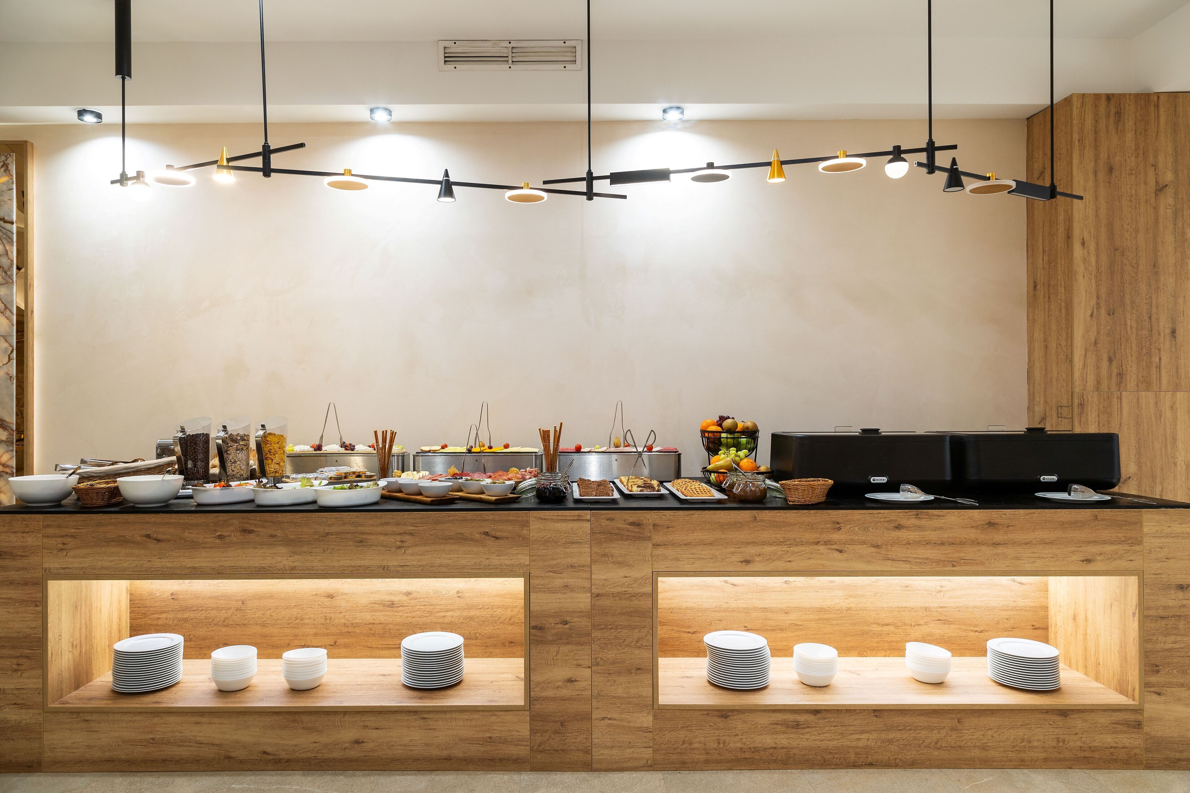A modern kitchen with a wooden countertop, multiple bowls, and a variety of food items.