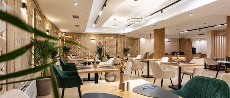 A modern dining area with wooden tables, upholstered chairs, and ambient lighting.