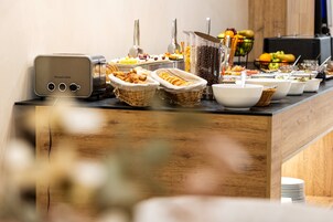 A buffet setup with various food items and a toaster.