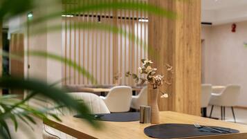 Un comedor moderno con una mesa de madera, un florero con flores y un diseño minimalista.