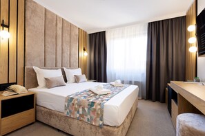 A modern hotel room with a large bed, a wooden headboard, a desk, and a television. - AMAR Design Hotel by HMG (Sofia)
