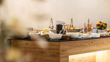 Una mesa de buffet con diversos alimentos y utensilios.