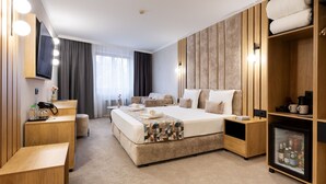 A modern hotel room with a large bed, a seating area, a vanity with a mirror, and a minibar. - AMAR Design Hotel by HMG (Sofia)