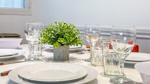A dining table set with plates, glasses, and a small potted plant.