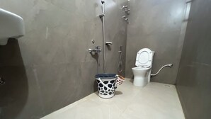 A small bathroom with a toilet, a shower, and a sink.