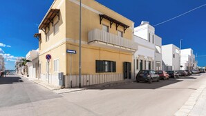 Eine Straße mit Gebäuden, parkenden Autos und blauem Himmel.