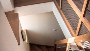 Eine Holztreppe mit Glastrennwand und einer strukturierten Wandverkleidung.