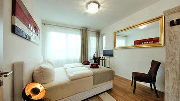 Une chambre d’hôtel avec un lit, une chaise, une télévision et un grand miroir.