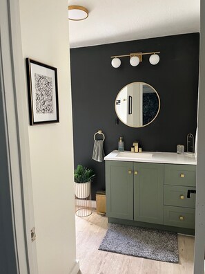 A modern bathroom with a dark wall, a white sink, and green cabinets. - Walk to Spring Training  - 3BR home in Scottsdale (Scottsdale)
