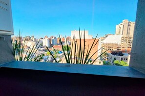 Enjoy breathtaking views of the city from this room's window, surrounded by lush greenery.