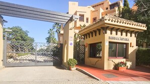 A building with a sign reading "BAHIALCÁNTARA" and a gated entrance. - Beachfront Apartment in San Pedro - Pass the Keys (Marbella)