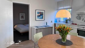 Una cocina moderna con comedor, una cama y un ventanal con vistas.