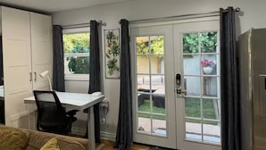 A compact kitchen with a dining area, a white cabinet, a small table with a chair, and a refrigerator.