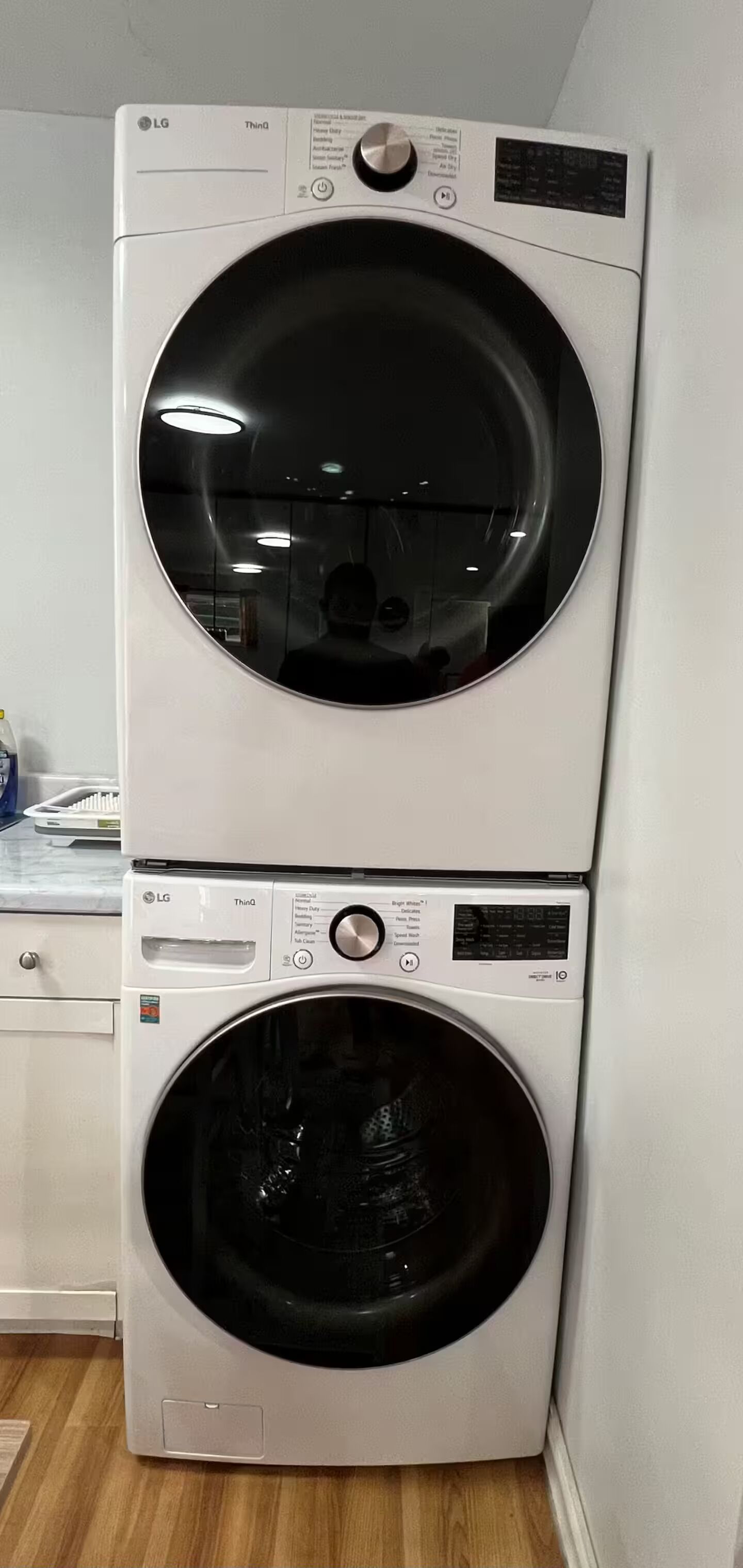 Un appareil combiné lave-linge et sèche-linge, de type « empilable », doté de panneaux de commande et d’un écran numérique.