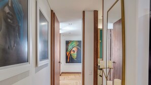 A hallway with wooden flooring, a painting on the wall, and a mirror with candles. - Elegant/Modern Apt in Poblado - Morph 1201 (Medellín)