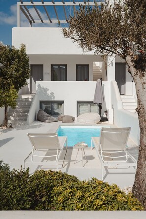 Eine moderne Villa mit Swimmingpool, weißen Wänden und einer Treppe, die zu der oberen Etage führt.