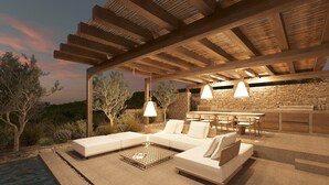 An outdoor patio with a stone wall, a wooden pergola, a white sofa, and a bar area. - Villa Aether Stelida Naxos (Naxos)