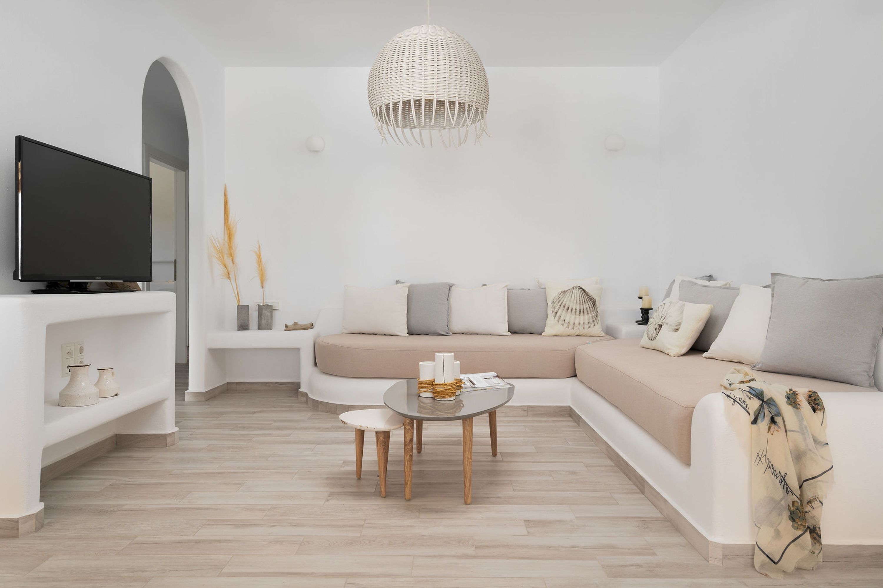 A modern living room with a sofa, a TV, and a round coffee table.