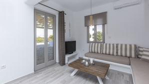 A modern living room with a sofa, television, and a wooden coffee table.