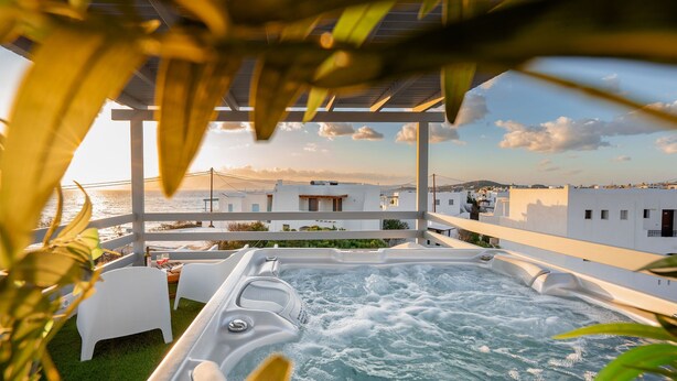 A hot tub with a view of the sea, white buildings, and a pergola. - Yara sea View Apartment Agia Anna (Naxos)