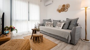 A modern living room with a grey sofa, wooden coffee table, and a large floor lamp. - Yara sea View Apartment Agia Anna (Naxos)