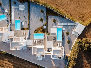 An aerial view of a resort with multiple swimming pools, sun loungers, and a well-maintained landscape. - Villa Ama Plaka With 3 Bedrooms and 3 Bathrooms (Naxos)