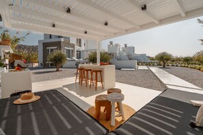 A modern outdoor seating area with a white pergola, a bar, and a view of a mountainous landscape. - Villa Ama Plaka With 3 Bedrooms and 3 Bathrooms (Naxos)