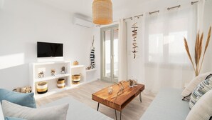 A modern living room with a wooden coffee table, a sofa, and a TV mounted on the wall.
