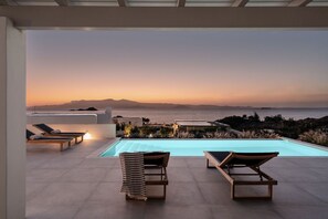 A rooftop pool area with lounge chairs and a view of the ocean at sunset. - 382905 - Villa Dia Mikri Vigla (Naxos)