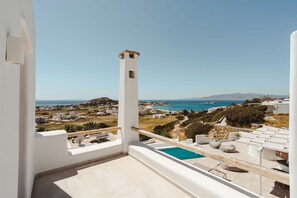A balcony with a pool, white walls, and a view of the sea and town. - 291424 - Villa Flo in Naxos (Naxos)