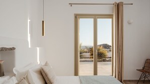 Une chambre avec un lit, une chaise et une vue sur l’extérieur grâce à une porte coulissante.