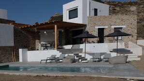 A modern villa with a stone exterior, a pool, and outdoor seating. - Villa Andalusia With 4 Bedrooms and 3 5 Bathrooms (Naxos)