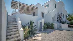 A modern white building with a covered outdoor area, stone steps, and a gravel courtyard. - 293102 - Casa Magnifica (Naxos)