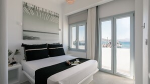 A modern bedroom with a large bed, a view of the sea, and a balcony with a railing. - Anamnesia Collection 2BR Apart Naxos Town (Naxos)