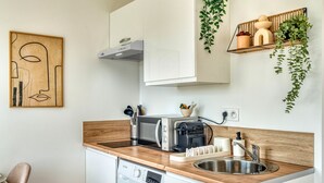 A compact kitchen with a microwave, toaster, and sink.
