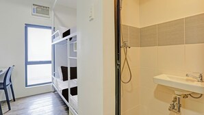 A room with a bed, a desk, and a shower area with a sink. - MyTown Madrid, Classy Hostel Bunkbeds Makati Metro Manila (Taguig)
