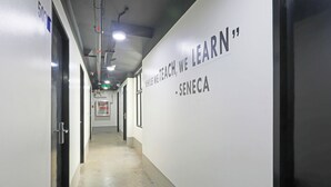 A hallway with a motivational quote on the wall, doors on the left, and a clean, tiled floor. - MyTown Madrid, Classy Hostel Bunkbeds Makati Metro Manila (Taguig)