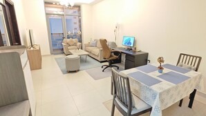 A spacious living area with a dining table, chairs, a sofa, and a computer desk. - Chic 1-bedroom apartment in enchanting Dubai with WiFi, fitness room (Dubai)