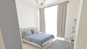A modern bedroom with a bed, a desk, and a chair. - Chic 1-bedroom apartment in enchanting Dubai with WiFi, fitness room (Dubai)