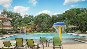 A swimming pool with green chairs and a water feature. - Fully-equipped home for the family (Boerne)