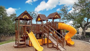 A wooden playground structure with slides and stairs. - Fully-equipped home for the family (Boerne)
