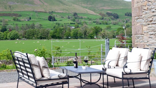 A terrace with two chairs and a table, overlooking a green valley with sheep. - Relaxing rural retreat (Sedbergh)