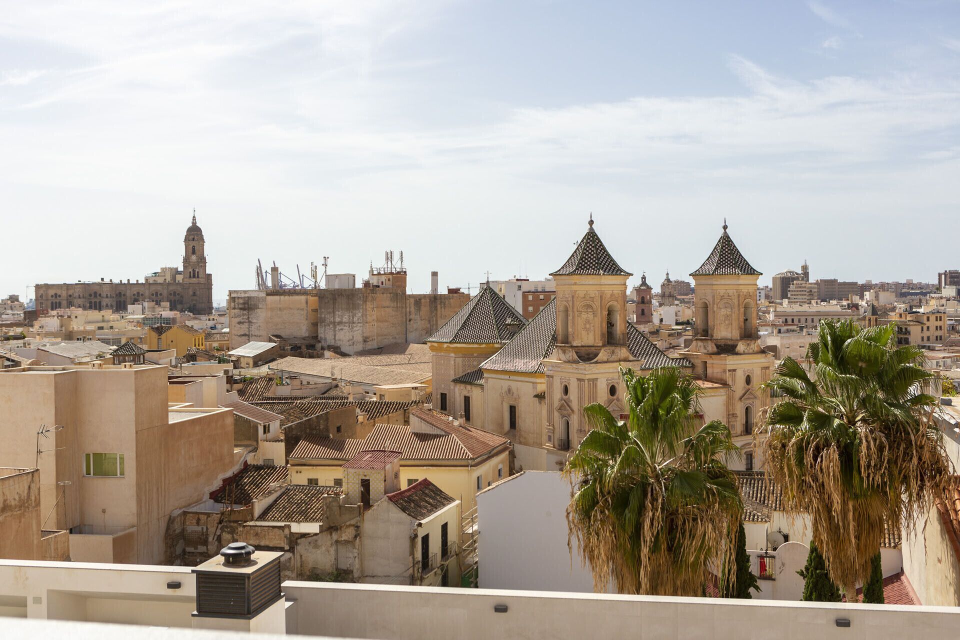 Un paysage urbain avec des bâtiments historiques, notamment une église remarquable dotée d’un clocher et une cathédrale.