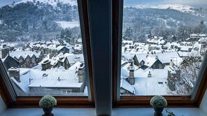 A view from a window overlooking a snow-covered town with houses and mountains in the background. - Ambleside View Ambleside, perfect for a romantic break surrounded by breath taking scenery (Ambleside)