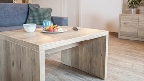 Un salon moderne avec une table basse en bois, un canapé et un meuble.
