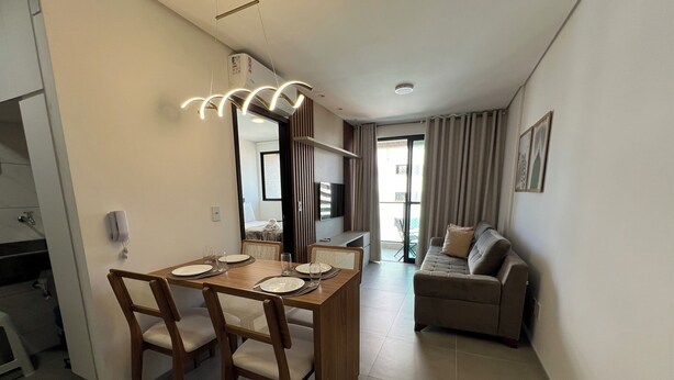 A modern living room with a dining area, a sofa, and a TV. - Edificio Promenade II Apt 508  (Maceió)
