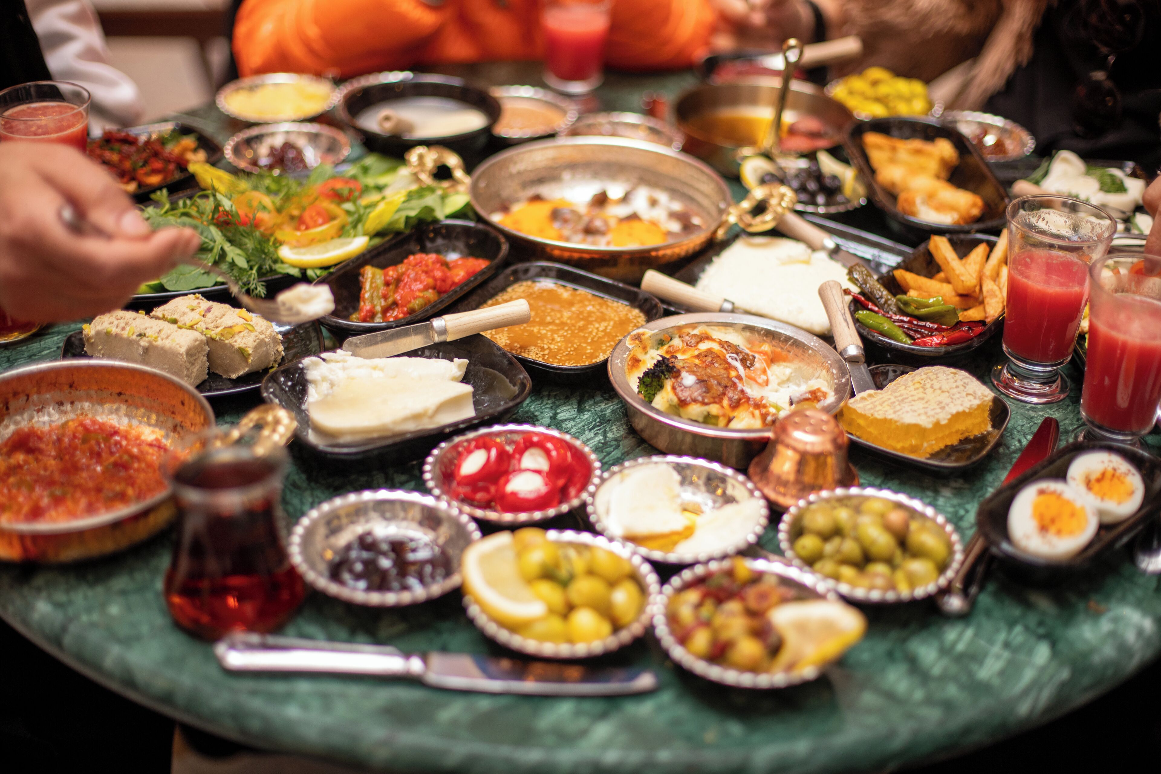 A table with various dishes and drinks, likely a buffet or communal meal setting.